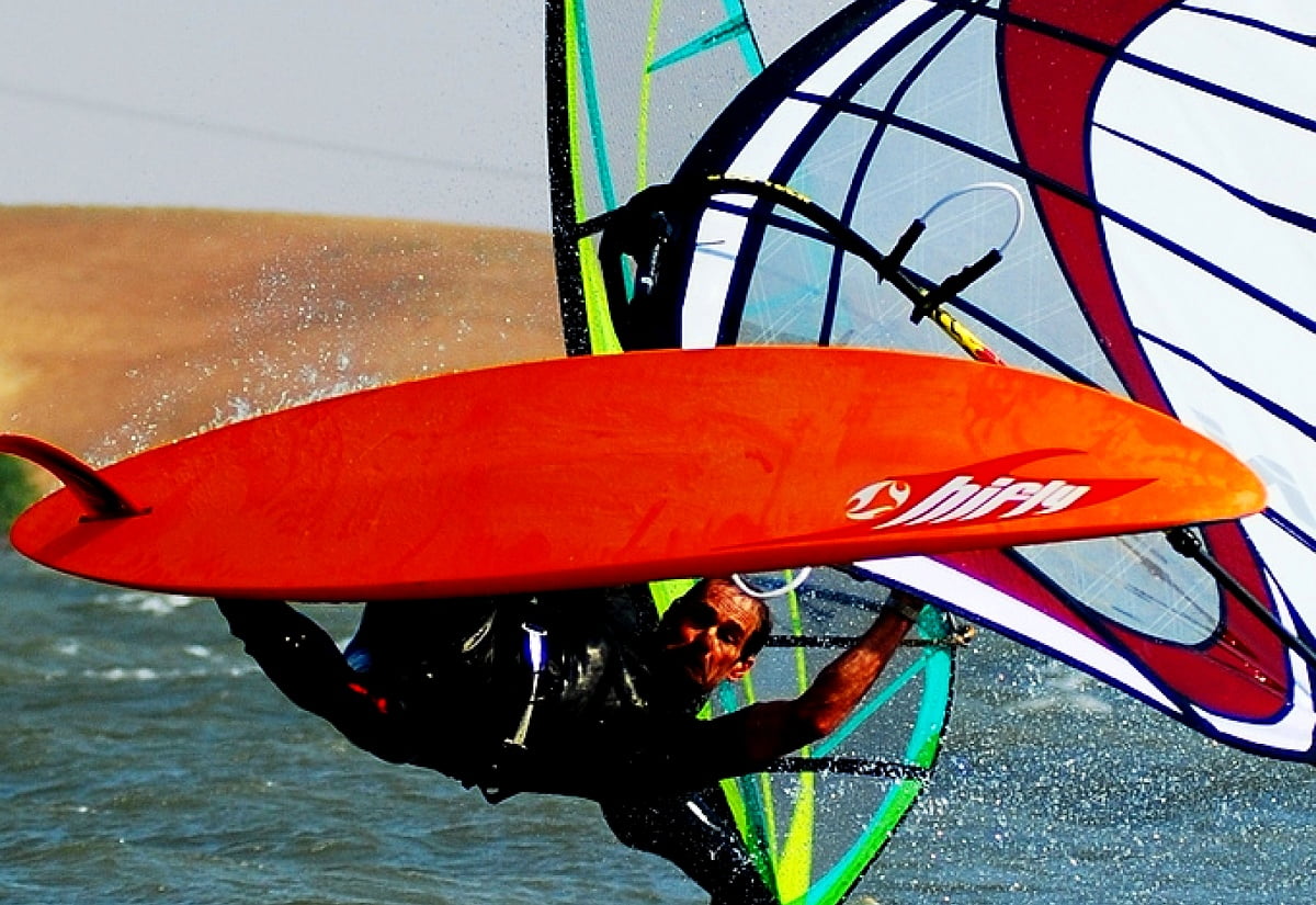 Homem carregando prancha de surf no ar - imagem para fundo de tela 1600x1100